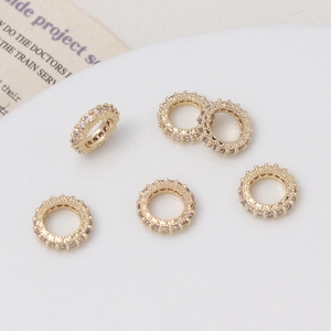 Vista macro de seis cuentas espaciadoras doradas con circonitas en micro-pavé