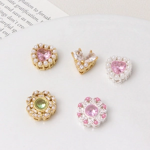 Close-up of five silver-plated flower beads with cubic zirconia for DIY jewelry making