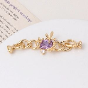 Macro detail of gold flower clasp connector with purple square zircon for DIY jewelry