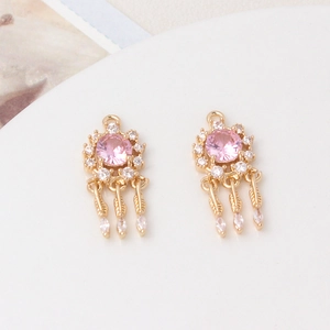 Detail of dreamcatcher charms with pink crystals and zircon feathers for DIY jewelry