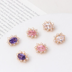 Detailed view of gold-plated oval zircon spacers in white, pink, and purple colors