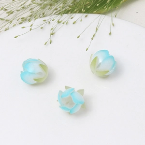 Makroaufnahme von drei handgefertigten hellblauen Gradient-Blütenknospen für DIY-Haarnadeln
