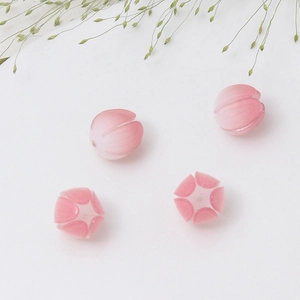 Dettaglio di quattro perline a petalo di fiore rosa traslucido per accessori fai da te