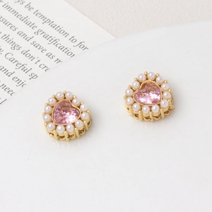 Detailed macro view of heart-shaped pink crystal with pearl border and gold-plated hollow base