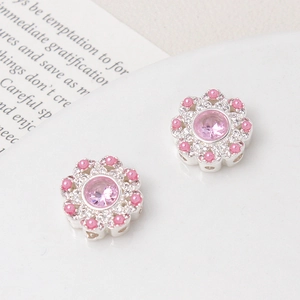 Detailed macro view of heart flower hollow charms with pink zircon and pearl inlays