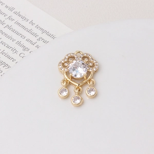 Detail of a gold ruyi lock pendant with micro-set zircons and tassel charm accents