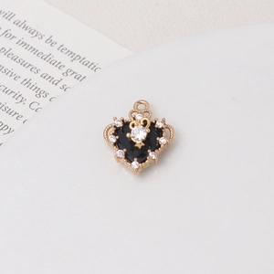 Macro shot of black enamel heart pendant with golden crown frame and sparkling zircons