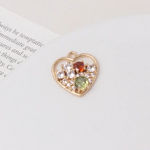 Macro shot of heart-shaped gold-plated pendant with colorful zircon stones and hanging loop