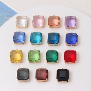 Flat lay of 15 colorful square faceted gemstone pendants in gold settings for DIY jewelry