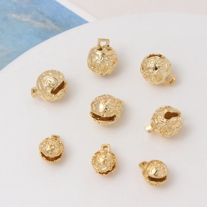 Detailed view of eight golden hollow-carved bell pendants for DIY jewelry making accessories