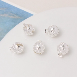 Detailed macro shot of five silver hollow carved bells for DIY jewelry accessories