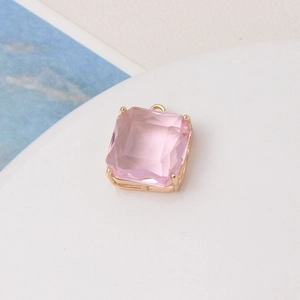 Macro shot of square pink faceted gemstone charm with gold claw setting for DIY jewelry