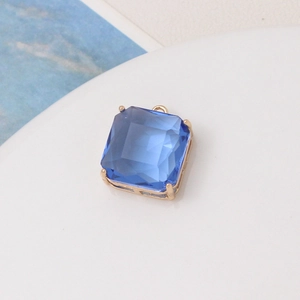 Detailed close-up of a blue square gemstone pendant with a gold-plated four-prong setting