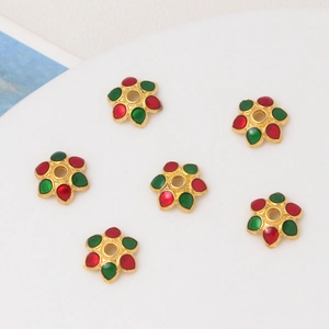 Macro detail of 8mm cloisonne flower bead caps with red and green enamel for DIY jewelry