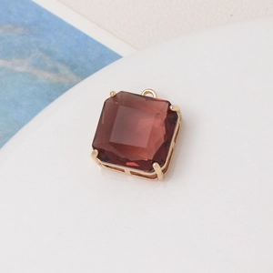 Close-up of a square cut reddish-brown gemstone pendant with a gold four-prong setting