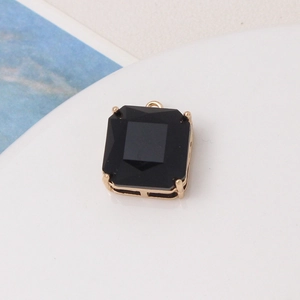 Macro shot of a black square gemstone pendant with a gold four-claw setting for DIY jewelry