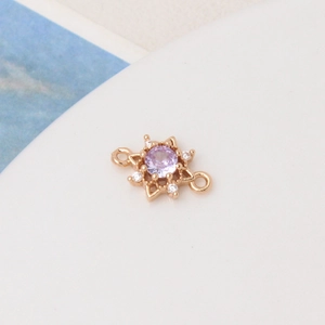 Macro detail of sunburst jewelry connector with purple cubic zirconia and side loops