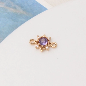 Detail of gold plated sun charm with purple zircon and white crystal micro-pave
