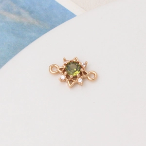Detail of gold star pendant connector with green zircon and white crystal accents