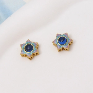 Dettaglio pendente stella dorata con gemma blu e smalto glitter per bigiotteria