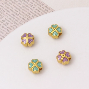 Macro detail of four-leaf clover beads in gold alloy with purple and green enamel filling