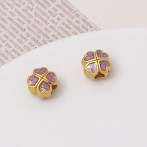 Detailed close-up of golden clover charms with purple enamel for DIY jewelry making