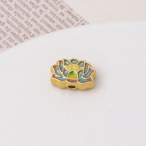 Detailed macro view of a gold lotus charm bead with colorful gradient enamel inlay
