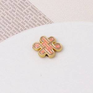 Macro shot of ancient gold alloy lotus flower bead with pink enamel and hole detail