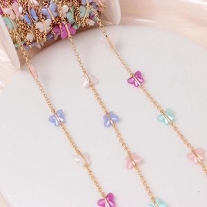 Detail of colorful acrylic butterfly charms on a gold plated DIY jewelry chain link