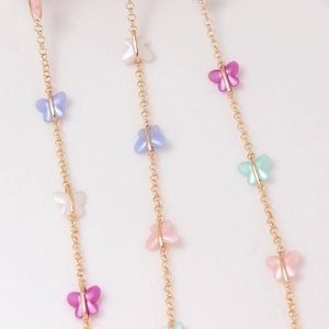 Detail of gold-plated chain featuring colorful acrylic butterfly charms for DIY jewelry