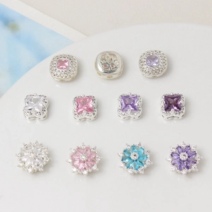 Dettaglio di ciondoli a fiore con zirconi colorati per bracciali gioielli fai da te