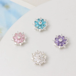 Dettaglio di perline distanziatrici a quadrifoglio in zircone blu, rosa, viola e bianco