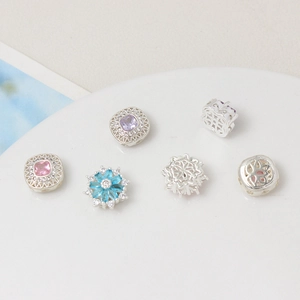 Dettagli di ciondoli geometrici e floreali in zircone per la creazione di bracciali