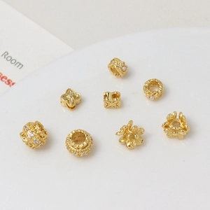 Macro shot of gold-plated flower-shaped beads with cubic zirconia and pearls for jewelry DIY
