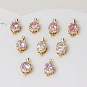 Detail of gold-plated copper connectors with pink, white, and purple cubic zirconia