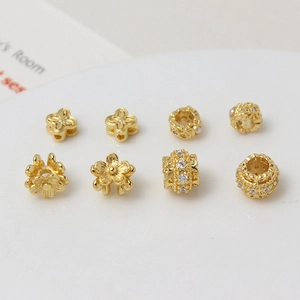 Macro shot of 8-piece gold-plated floral spacer beads with sparkling zircon accents