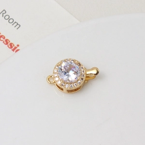 Macro shot of gold-plated round clasp with large white zircon and paved crystals