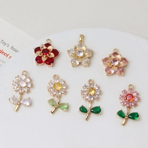 Detailed flat lay of colorful zircon daisy flower charms and floral pendants with gold plating