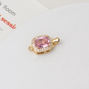 Detailed close-up of a gold-plated clasp with rectangular pink stone and zircon border