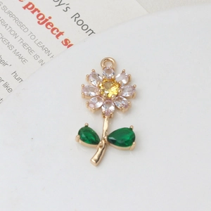 Macro detail of sunflower pendant with pink petals, yellow core and green gem leaves