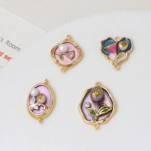 Macro detail of floral enamel jewelry connectors with pearls and gold-plated edges