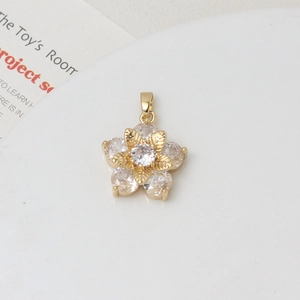 Macro detail of gold flower pendant with sparkling zircon center and textured petals