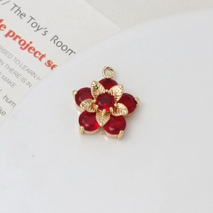 Macro detail of red zircon daisy flower pendant with gold metal leaf for DIY jewelry