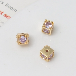 Detailed macro view of 18k gold plated cube beads with purple cubic zirconia for DIY