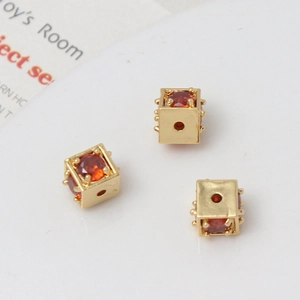 Macro detail of cube bead with 18k gold plating and sparkling red cubic zirconia