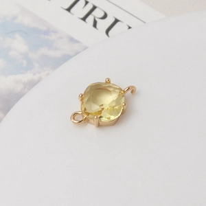 Vue macro d'un connecteur en pierre jaune carrée et métal doré pour bijoux DIY