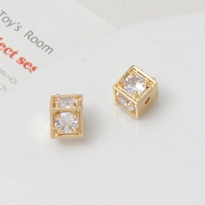 Macro shot of a 18k gold plated hollow cube bead with cubic zirconia for jewelry making