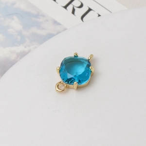 Vue macro détaillée d'un pendentif en cristal bleu mer carré avec serti griffes doré pour bijoux