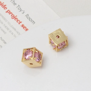 Macro shot of 18k gold plated square beads with pink cubic zirconia for jewelry making