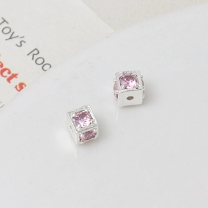 Macro shot of silver cube spacers with pink zircon insets for DIY jewelry making